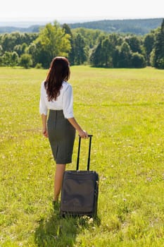 Young businesswoman sunny meadows attractive with suitcase luggage