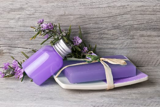 Rosemary branches with flowers and rosemary gel on an old wooden shelf.