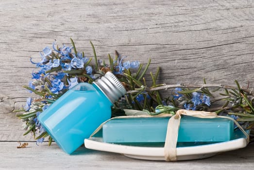 Rosemary branches with flowers and rosemary gel on an old wooden shelf.