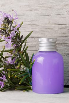 Rosemary branches with flowers and rosemary gel on an old wooden shelf.