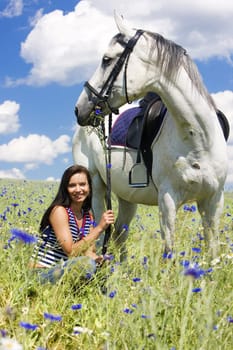 equestrian with a horse on meadow