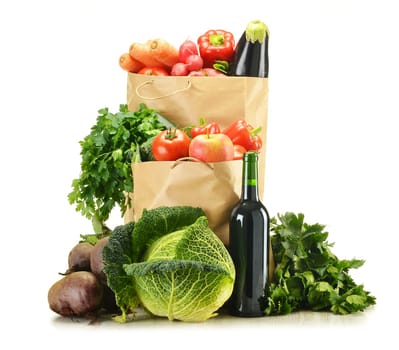 Composition with raw vegetables and shopping bag isolated on white