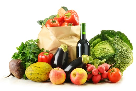 Composition with raw vegetables and shopping bag isolated on white