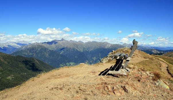 Panorama - A wooden bench on the summit in South Tyrol