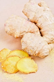 Fresh, dried and powdered ginger at brown background