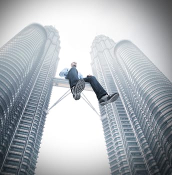man sit on skyscrape bridge