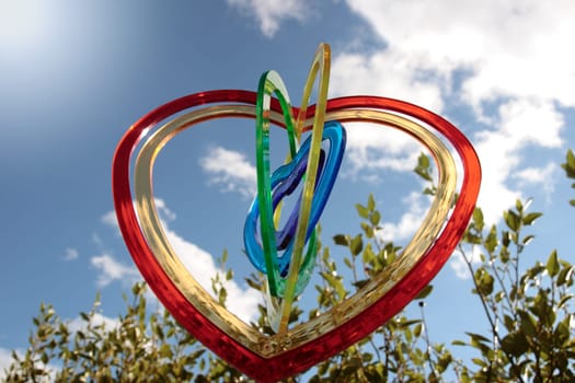 six heart shaped plastic pieces one inside the other on a cloudy sunny background as if floating on air