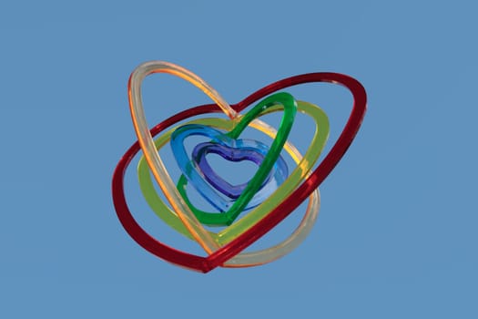 six heart shaped plastic pieces one inside the other on a blue background as if floating on air