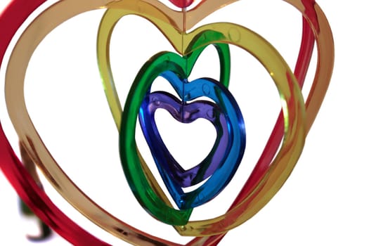 six heart shaped plastic pieces one inside the other on a white background with champagne in background