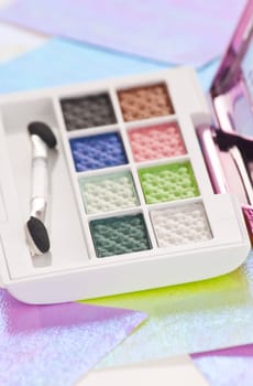 Eye shadow kit over colourful papaers background