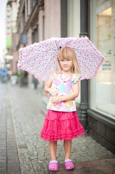 Little girl with a pink umbrella on a rainy day in Helsinki, Finland
