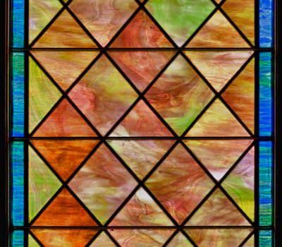 Stained glass window with diamond shapes and overall red brown color