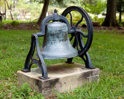 Old bell from church tower in frame in garden