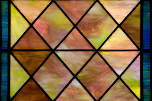 Stained glass window with diamond shapes and overall red brown color