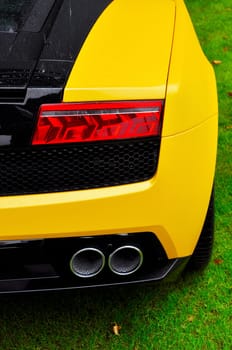Rear detail of an Italian yellow and black supercar after the rain, Lamborghini Gallardo