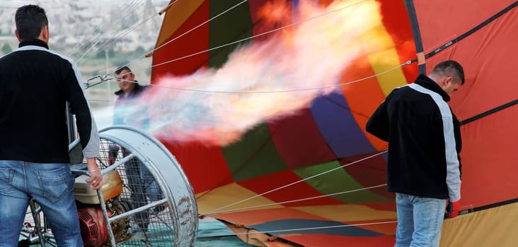 flames hot air balloon assistants getting balloon ready for next flight, multi colors, landscape, crop space and copy area