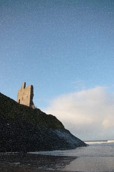 a view of the castle overlooking the beach in ballybunion co kerry ireland during a snow storm