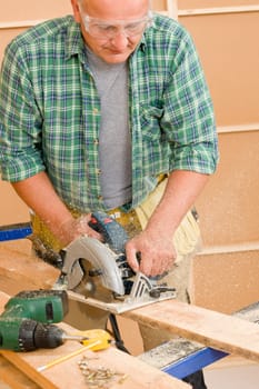 Handyman mature home improvement cut wood with jigsaw