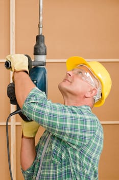 Handyman mature home improvement working with jackhammer diy