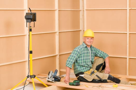 Mature handyman home improvement installing wooden floor in new house