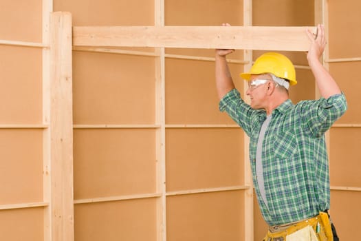 Handyman home improvement carpenter mature professional fitting wooden beam