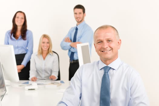 Business team happy mature businessman with attractive colleagues looking files