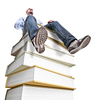 caucasian man sit on huge book pile