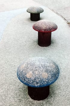 three plastic toadstools in a snow covered playground