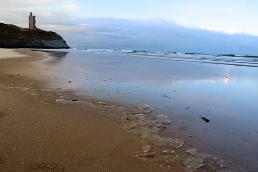 an icy beach view of the castle overlooking the beach in ballybunion co kerry ireland