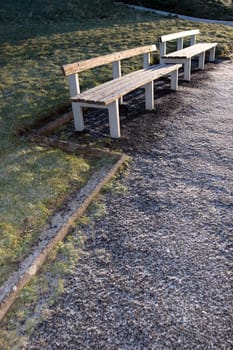 two benches beside a park footpath