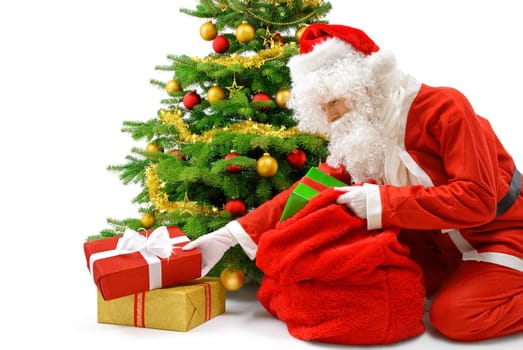 Friendly Santa Claus puts gift packs under the Christmas tree
