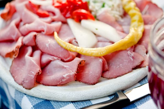 Meat plate of cold-cuts with self-made ingredient on wooden plate