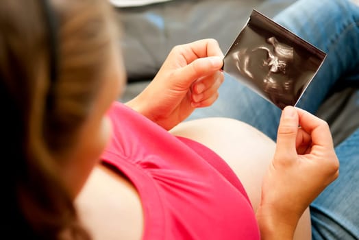 Pregnant woman looking at ultrasound image