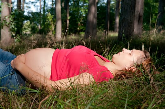 Pregnant young woman relaxing in the forest