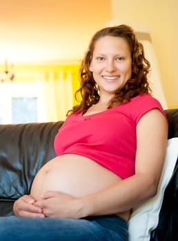 pregnant young woman sitting on the couch