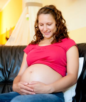 pregnant young woman sitting on the couch