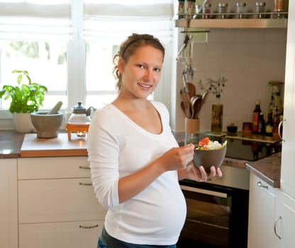 Pregnant young woman with salad