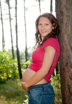 Pregnant young woman in the forest