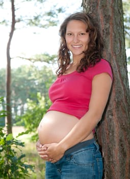 Pregnant young woman in the forest