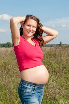 Pregnant young woman on a meadow