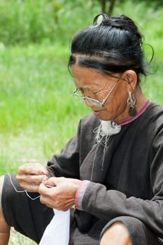 Old woman doing needlework,ethnic minority in Laos