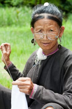 Old woman doing needlework,ethnic minority in Laos