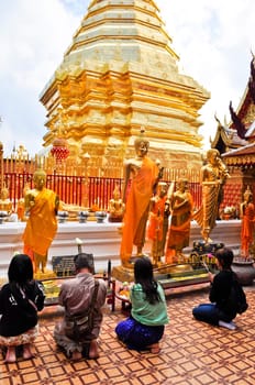 Chiang Mai, Thailand - December 22:  People praying at a famous buddhist temple in Thailand on December 22, 2010