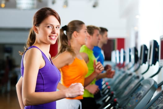 People running on treadmill in gym