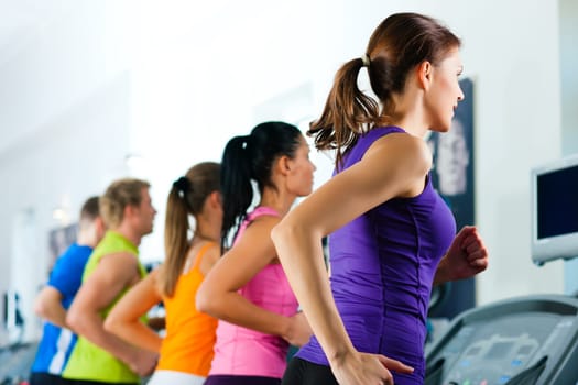 People running on treadmill in gym