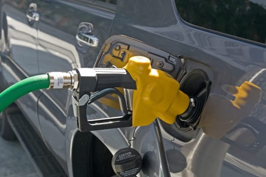 A gasoline station filling nozzle in a gas tank
