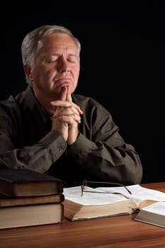 Senior pastor meditating and searching guidance in prayer
