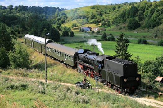 Beautiful hilly landscape with an old retro steam train