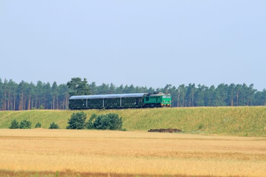 Passenger train passing through polish countryside