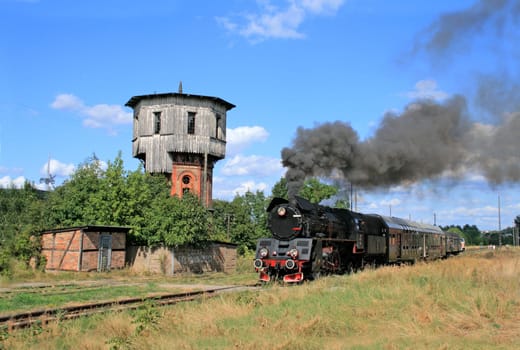 Old retro steam train starting from the small station